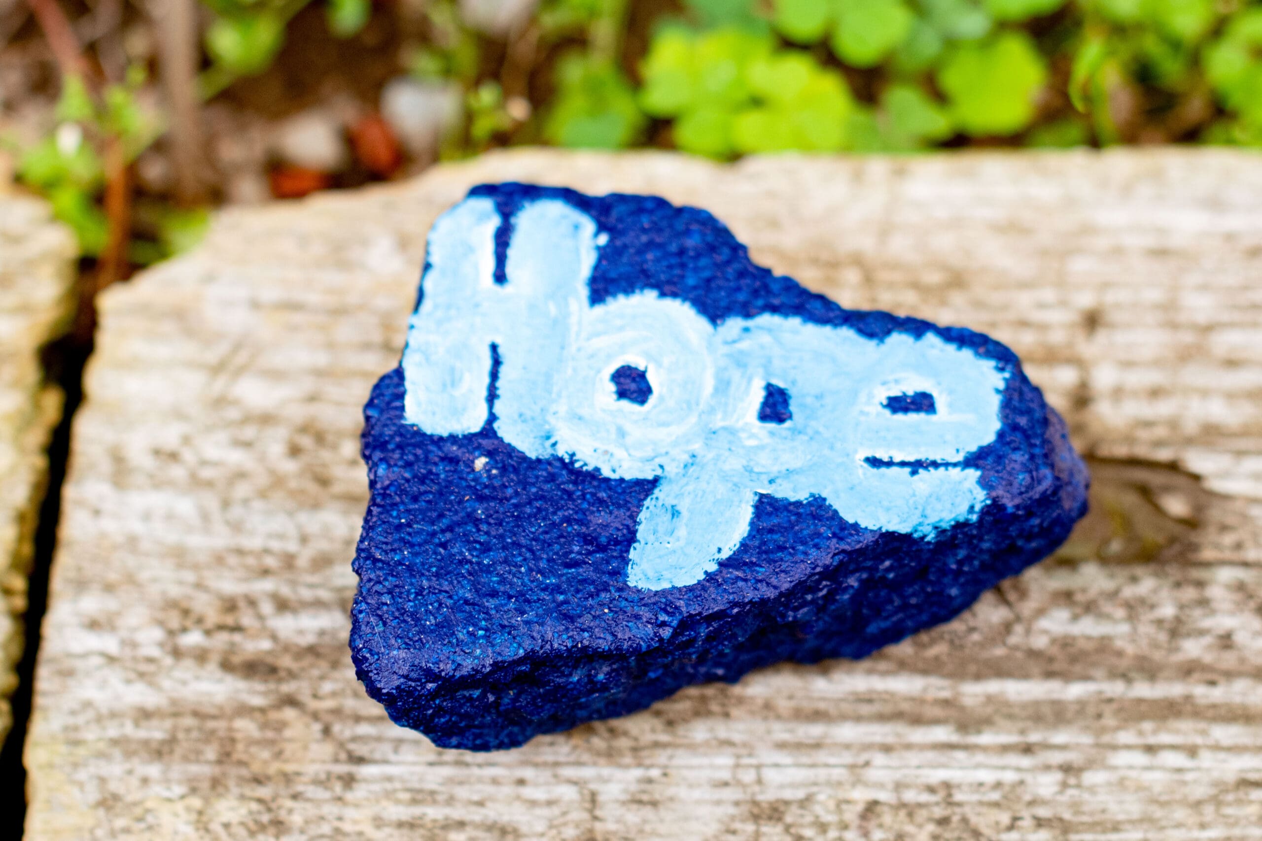 Blue heart-shaped rock with natural background